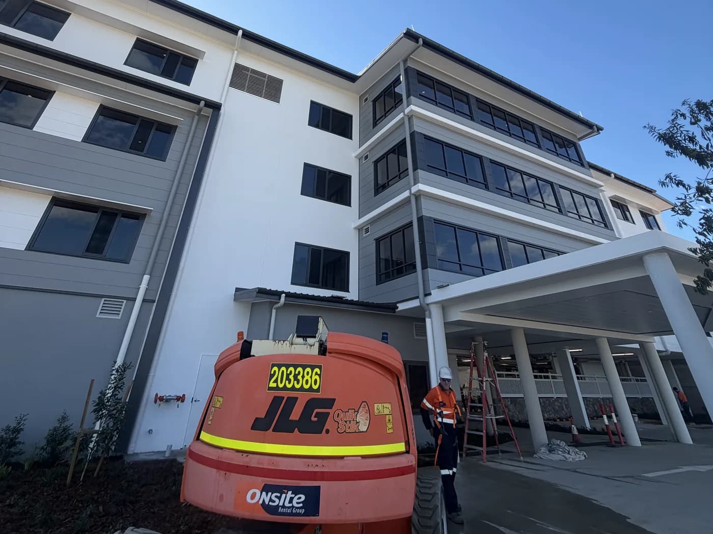 Multi-storey building exterior clean from an elevated work platform, Gladstone