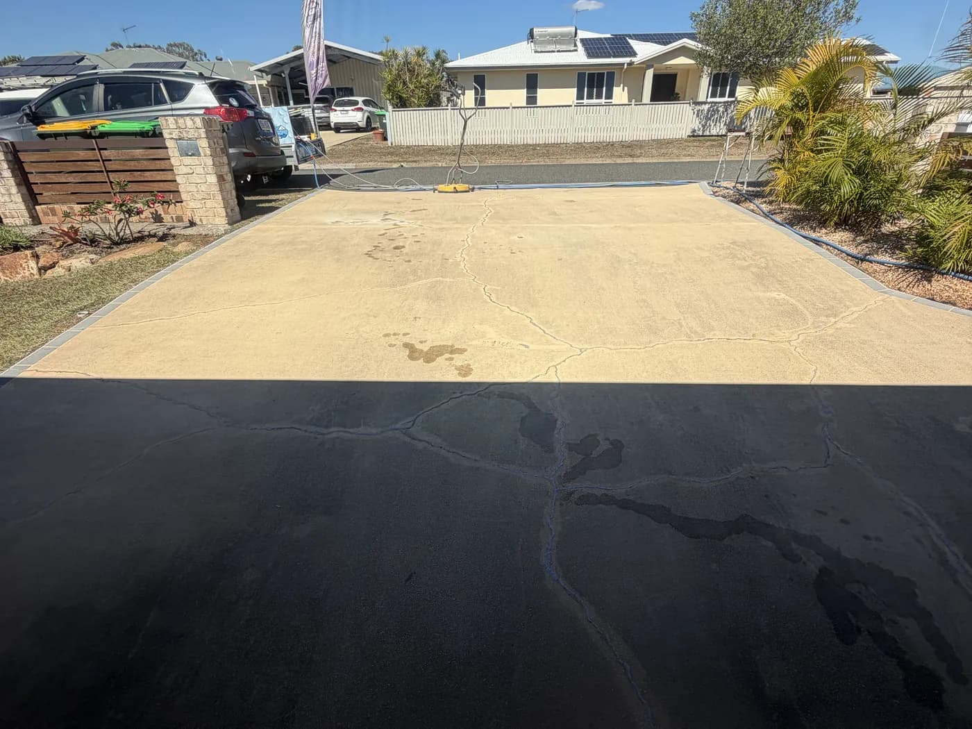 Driveway pressure clean in progress in Tannum Sands, cleaned concrete beside the section still to do